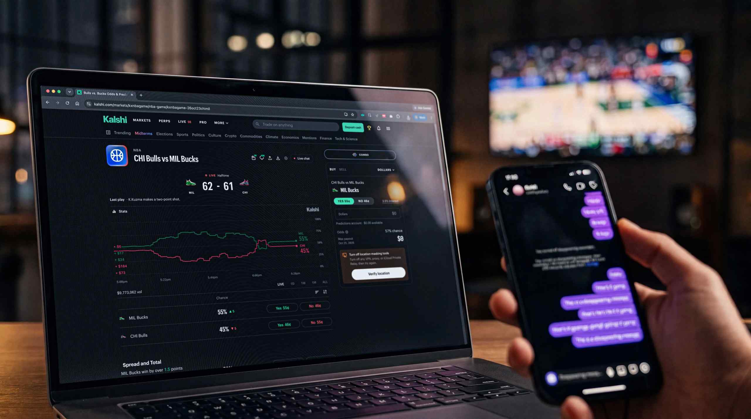 Kalshi running on a desktop with a basketball game playing in the background. Meanwhile a man types messages on an iPhone in the foreground.