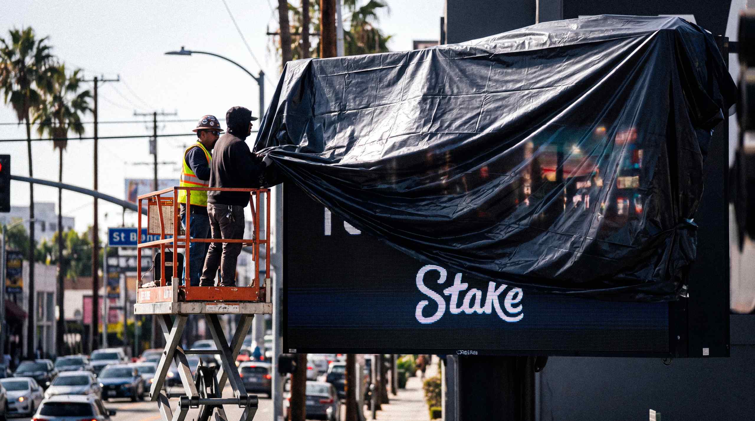 A billboard featuring the sweepstakes casino Stake getting taken down.